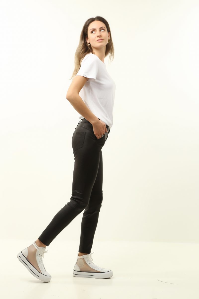 blond woman wearing white shirt and black leather pants on white background