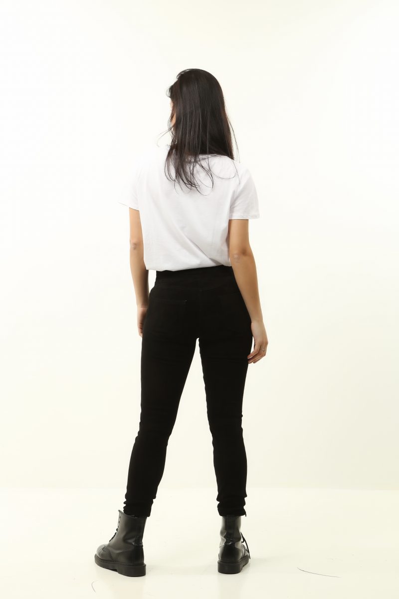dark haired woman wearing white shirt and black leather pants on white background