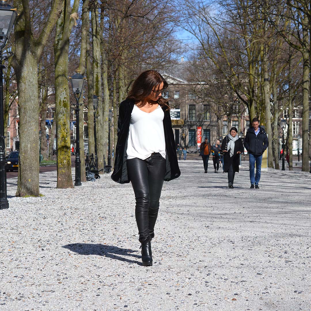 Woman strolling through Park in fashionable leather pants
